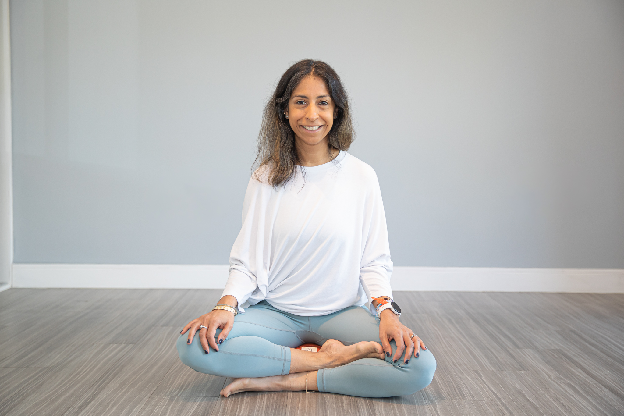 Ayurvedic consultant Kiran sits cross legged in meditation pose on the floor